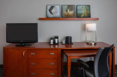 a desk with a television and a lamp on it at Courtyard Orlando International Drive/Convention Center in Orlando