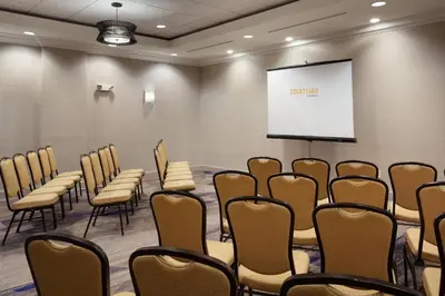 a conference room with chairs and a screen at Courtyard by Marriott Orlando Lake Buena Vista in the Marriott Village in Orlando