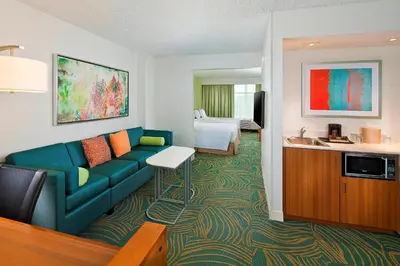 a living room with a couch and a bedroom at SpringHill Suites by Marriott Orlando Lake Buena Vista in Marriott Village in Orlando