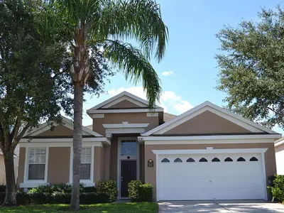 a house with a palm tree in front of it at Sun Palm Disney Villa in Kissimmee