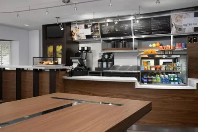 a fast food restaurant with a counter and a bar at Courtyard by Marriott Orlando East/UCF Area in Orlando