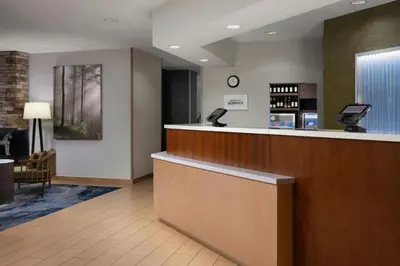 a hotel lobby with a reception counter and a waiting room at Fairfield Inn Orlando Airport in Orlando