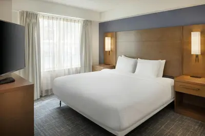 a hotel room with a large bed and a flat screen tv at Residence Inn by Marriott Orlando East/UCF Area in Orlando