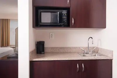a kitchen with a sink and a microwave at SpringHill Suites Orlando Airport in Orlando