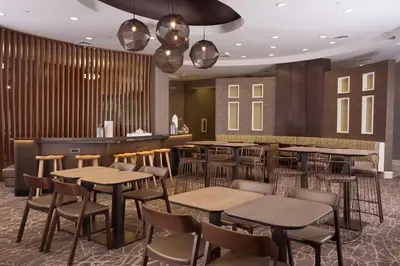 a restaurant with tables and chairs and a bar at SpringHill Suites Orlando Airport in Orlando