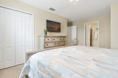 a large bedroom with a large bed and a refrigerator at Five Bedrooms Home with Pool 4851 in Kissimmee