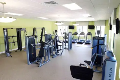 a gym with rows of treadmills and machines at Five Bedrooms Home with Pool 4851 in Kissimmee