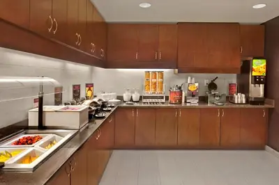 a kitchen with wooden cabinets and a counter top at Residence Inn Orlando Lake Mary in Lake Mary