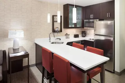 a kitchen with a white counter top and a refrigerator at Residence Inn by Marriott Near Universal Orlando in Orlando