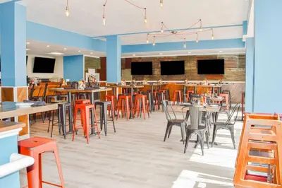 a dining room with tables and chairs in a restaurant at Radisson Hotel Orlando Lake Buena Vista South in Kissimmee