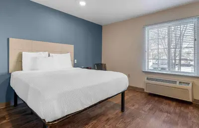 a bedroom with a large bed and a window at Extended Stay America Select Suites - Orlando - South in Orlando