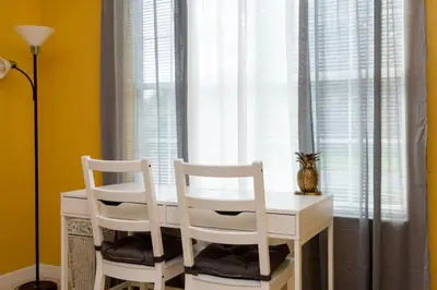 two white chairs sitting at a white table in front of a window at 7 Bedroom Mansion Near Disney in Kissimmee