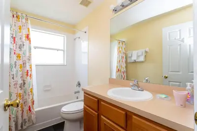 a bathroom with a sink and a toilet and a shower at 7 Bedroom Mansion Near Disney in Kissimmee