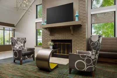 a living room with two chairs and a fireplace at Residence Inn by Marriott Orlando Altamonte Springs Maitland in Orlando