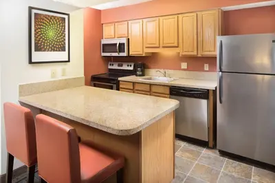 a kitchen with a stainless steel refrigerator and cabinets at Residence Inn by Marriott Orlando Altamonte Springs Maitland in Orlando