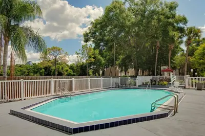 a swimming pool with a fence and trees at Residence Inn by Marriott Orlando Altamonte Springs Maitland in Orlando