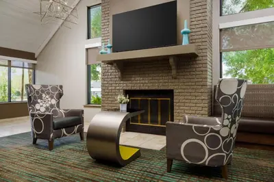 a living room with two chairs and a fireplace at Residence Inn by Marriott Orlando Altamonte Springs Maitland in Orlando