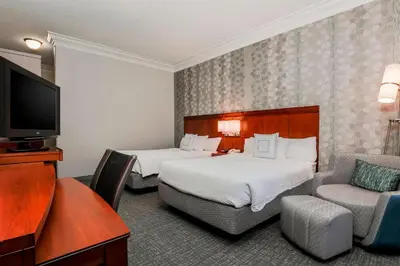 a hotel room with two beds and a flat screen tv at Courtyard by Marriott Orlando Lake Mary North in Lake Mary