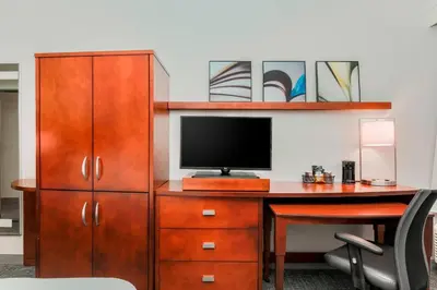 a desk with a television and a desk with a chair at Courtyard by Marriott Orlando Lake Mary North in Lake Mary