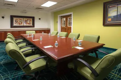 a conference room with a large wooden table and chairs at SpringHill Suites by Marriott Orlando North-Sanford in Sanford