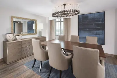 a dining room with a table and chairs and a mirror at Orlando Marriott Lake Mary in Lake Mary
