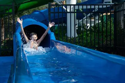 a young child is sliding down a water slide at Disney Bunk Room--Windsor Hills in Orlando