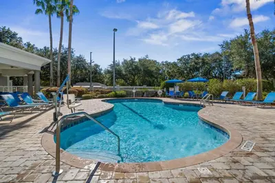 a swimming pool with blue lounge chairs and a resort at Lake Buenavista Apartments close to Disney in Orlando