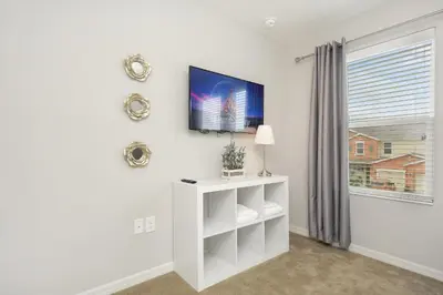a white living room with a tv on a wall at Four Bedrooms Townhome 5108K in Kissimmee
