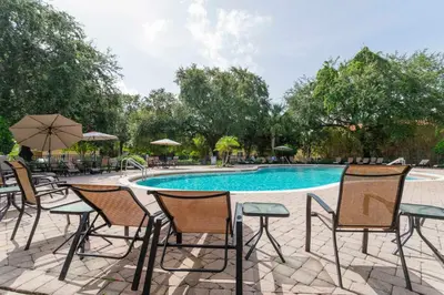 a group of chairs and a swimming pool at Four Bedrooms Townhome 5108K in Kissimmee