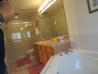 a bathroom with a tub and a sink and a toilet at 3 Bedroom Standard Davenport Home FL 33897 in Orlando