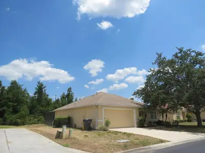 a house with a garage on the side of the road at 3 Bedroom Standard Davenport Home FL 33897 in Orlando