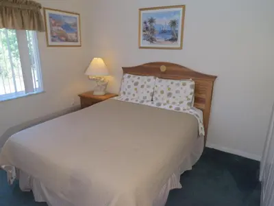 a bedroom with a bed and a lamp and a window at 3 Bedroom Standard Davenport Home FL 33897 in Orlando