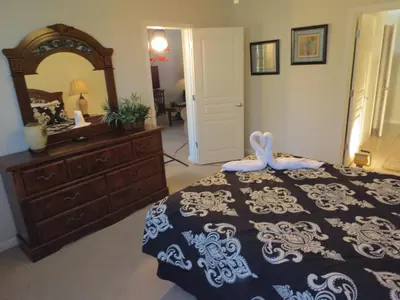 a bedroom with a bed with a dresser and a mirror at Formosa Garden Pool Home in Kissimmee
