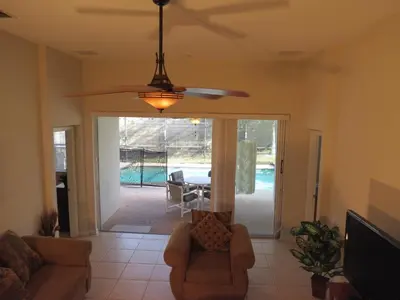 a living room with a couch and a ceiling fan at Formosa Garden Pool Home in Kissimmee