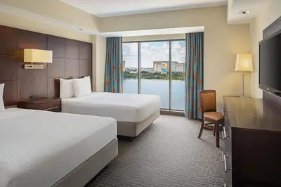 a hotel room with two beds and a large window at Plaza Suites On International Drive Near Universal Epic in Orlando