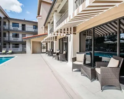 a patio with chairs and a pool in a building at Quality Inn & Suites By the Parks in Orlando