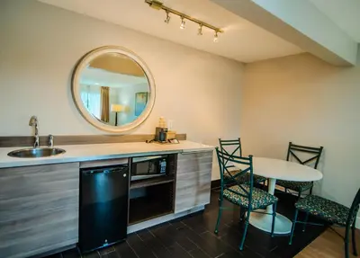 a kitchen with a sink and a table with chairs at Quality Inn & Suites By the Parks in Orlando