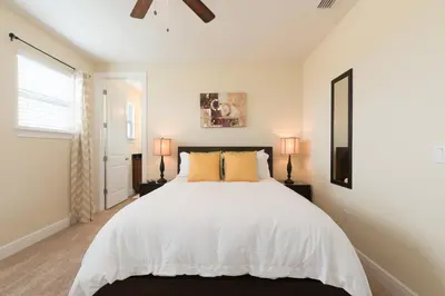 a bedroom with a large white bed with two lamps at Wilmington Loop 6 Br Luxury Villa with Pool and Spa in Orlando