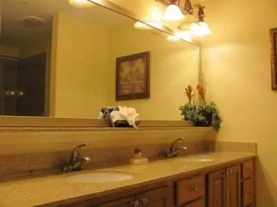 a bathroom with two sinks and a large mirror at Penthouse Blue Heron Condo in Orlando