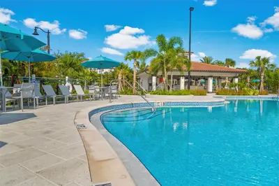 a swimming pool with chairs and umbrellas at a resort at Vero`s Gem Condo in Orlando