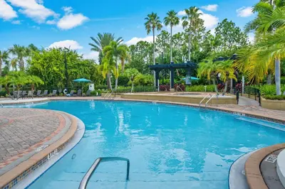 a swimming pool at a resort with palm trees at Spring Lakeview Condo in Orlando
