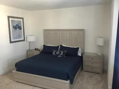 a bedroom with a blue bed and two night stands at DREAM HOUSE, ECOLAB Sanitzed NEAR DISNEY, POOL FENCE in Orlando