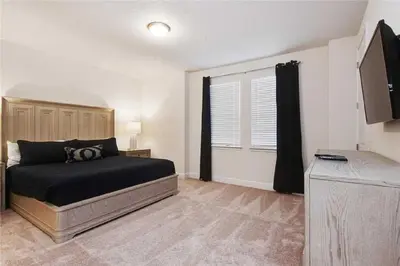 a bedroom with a bed and a television in it at DREAM HOUSE, ECOLAB Sanitzed NEAR DISNEY, POOL FENCE in Orlando