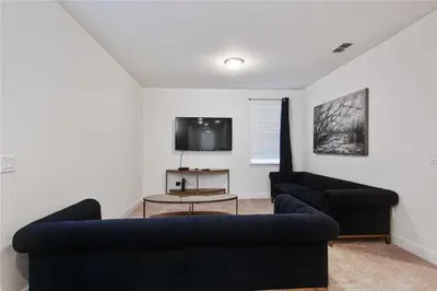 a living room with a couch and a tv at DREAM HOUSE, ECOLAB Sanitzed NEAR DISNEY, POOL FENCE in Orlando