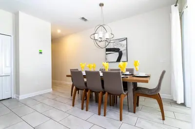 a dining room with a wooden table and chairs at Four Bedrooms TownHome 4861 in Kissimmee