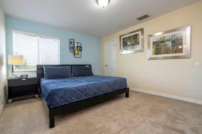 a bedroom with a bed with a blue comforter at Five Bedrooms TownHome with Pool 4849 in Kissimmee