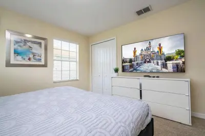 a bedroom with a bed and a tv on the wall at Five Bedrooms TownHome with Pool 4849 in Kissimmee