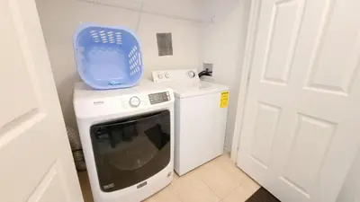 a washing machine with a blue container on top of it at Windsor Palm Condo #213421 in Kissimmee