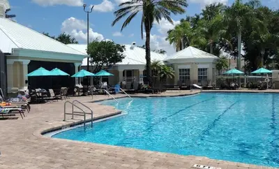 a pool at a resort with chairs and umbrellas at Windsor Palm Condo #213421 in Kissimmee