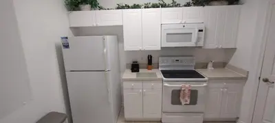 a kitchen with white cabinets and a white refrigerator at Windsor Palm Condo #213421 in Kissimmee
